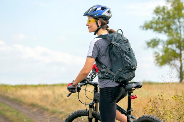 Bella ragazza in sella a una bicicletta in natura