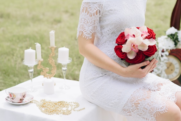 bella ragazza in un abito bianco con un mazzo di fiori