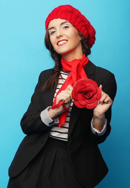 Bella ragazza in un berretto rosso. Stile francese. Su sfondo blu.