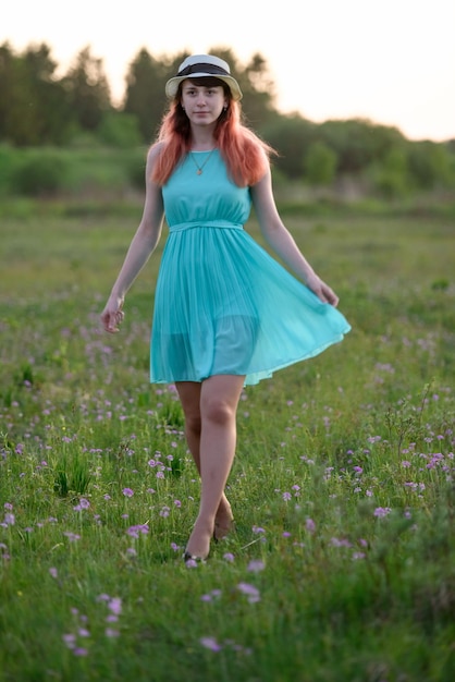 Bella ragazza in un campo con fiori