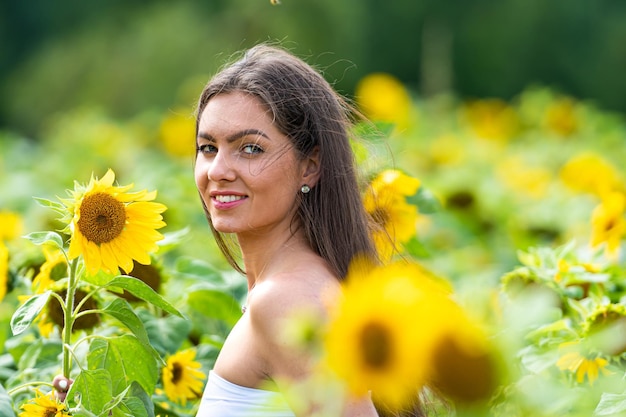 Bella ragazza in un campo di girasoli donna con girasoli gialli girasoli