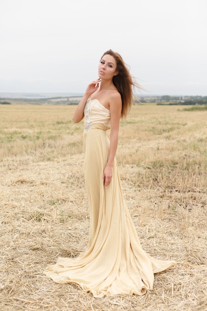 Bella ragazza in un campo di grano