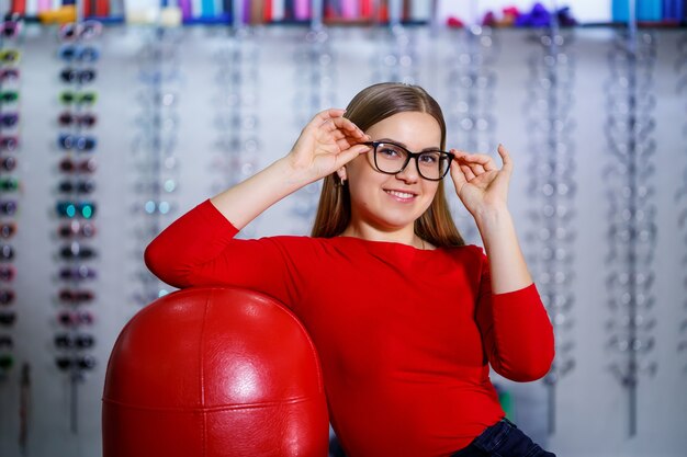 bella ragazza in un centro di oftalmologia prende gli occhiali per la correzione della vista