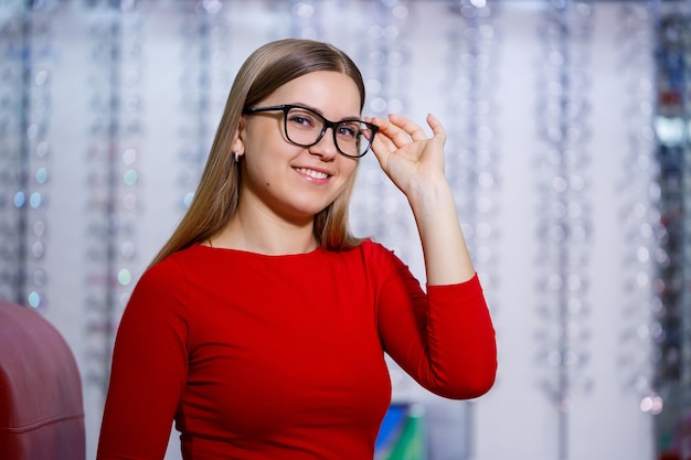 bella ragazza in un centro di oftalmologia prende gli occhiali per la correzione della vista