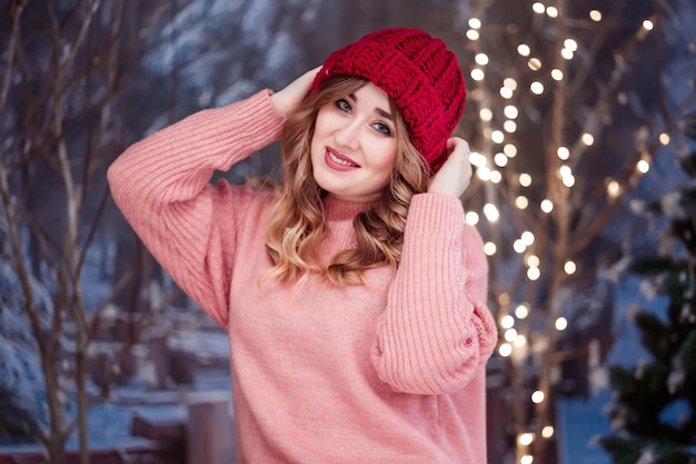 Bella ragazza in un maglione rosa e un cappello rosso