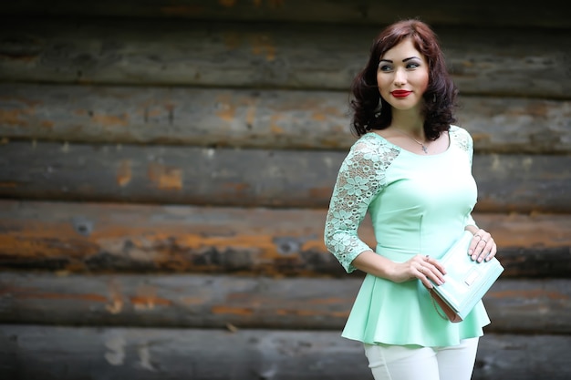 Bella ragazza in un parco di foglie di primavera nel pomeriggio