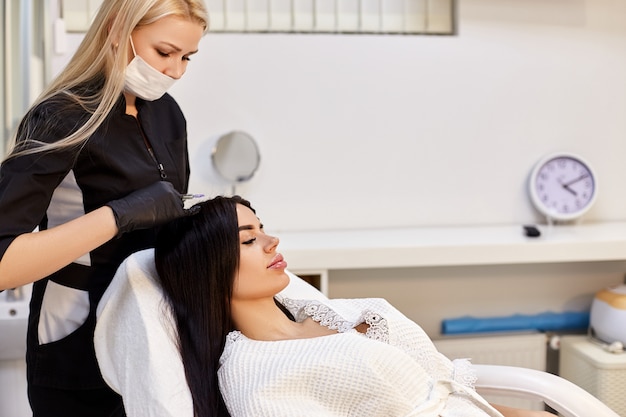 Bella ragazza in un salone di bellezza alle procedure di cosmetologia