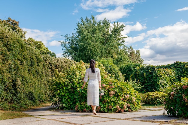 Bella ragazza in un vestito bianco nel parco