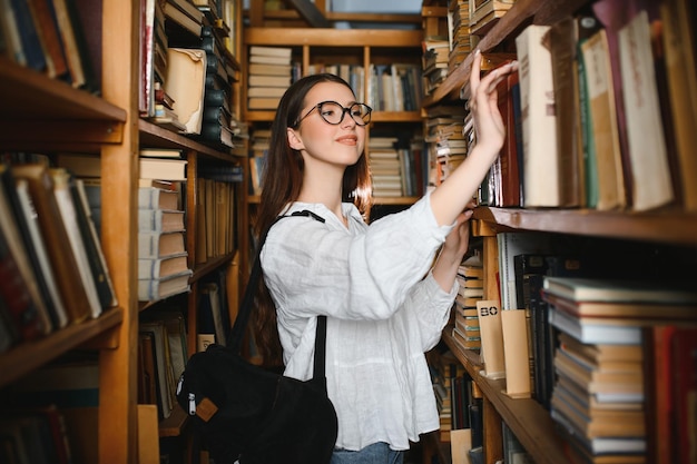 Bella ragazza in una biblioteca