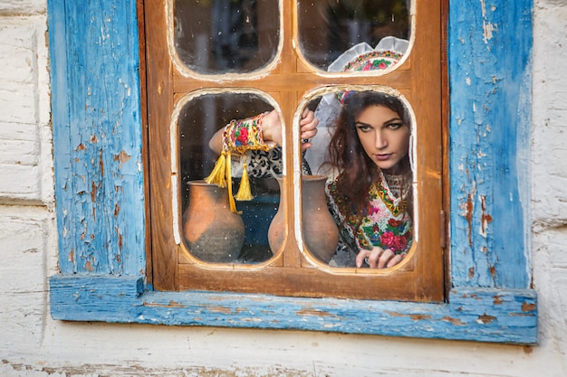 Bella ragazza in una capanna in costume nazionale slava.