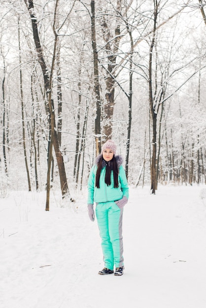 Bella ragazza in una foresta invernale bianca.