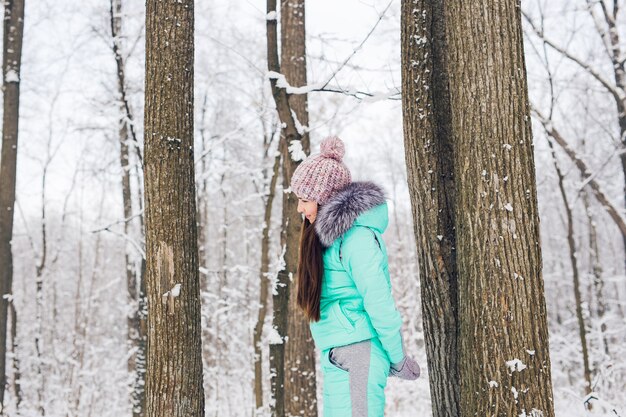 Bella ragazza in una foresta invernale bianca.