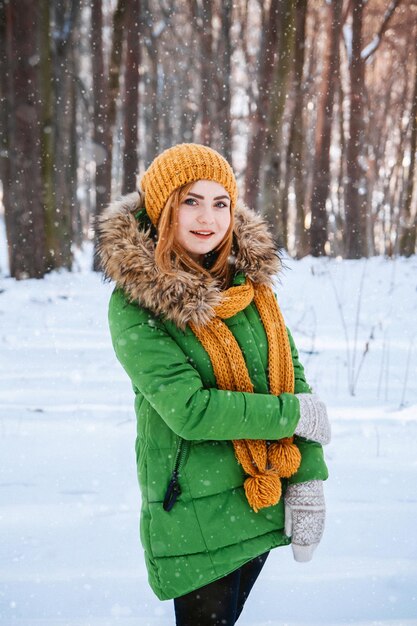 Bella ragazza in una foresta invernale Ritratto invernale di una ragazza vestita con berretto e sciarpa