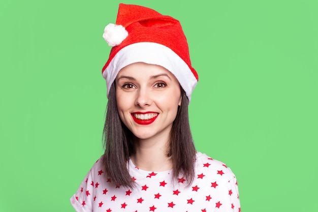 bella ragazza in una maglietta con una stella e un cappello di babbo natale con rossetto rosso sulle labbra