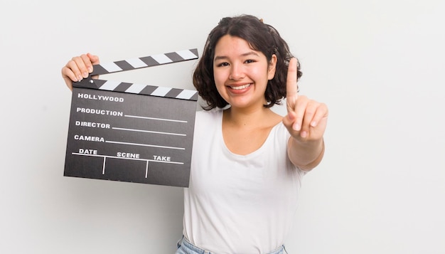 Bella ragazza ispanica che sorride con orgoglio e sicurezza facendo il concetto di cinema numero uno