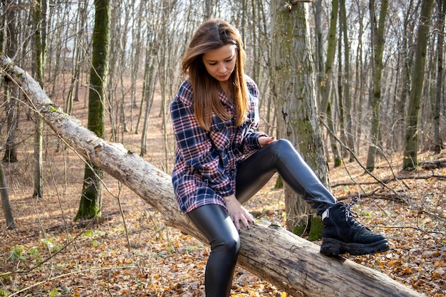 Bella ragazza nel bosco vicino agli alberi