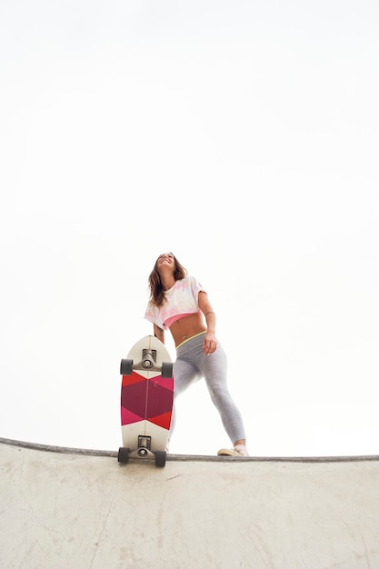 Bella ragazza nel parco con uno skateboard