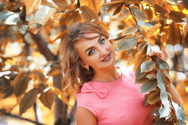 Bella ragazza nel parco in una passeggiata di una giornata di sole autunnale