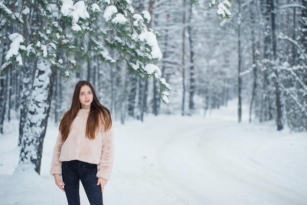 Bella ragazza nella foresta invernale