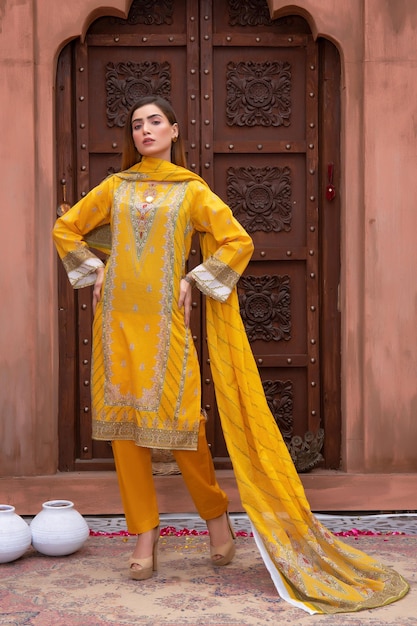 Bella ragazza pakistana servizio fotografico di moda che indossa un vestito giallo Desi