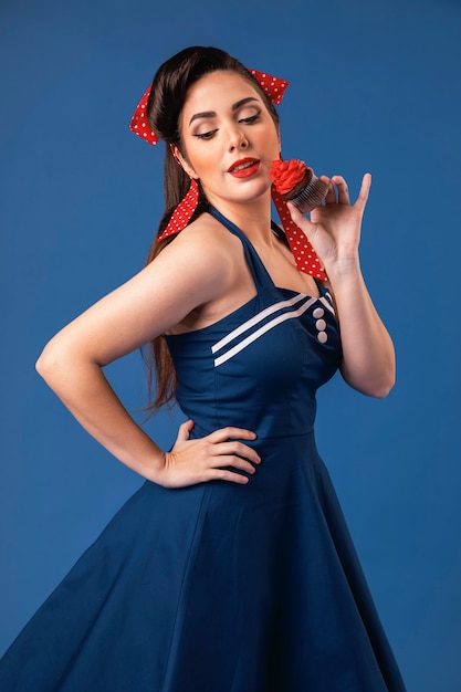 Bella ragazza pinup in posa in uno studio blu