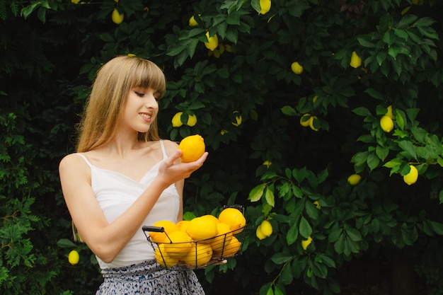 Bella ragazza raccoglie un limone da un albero