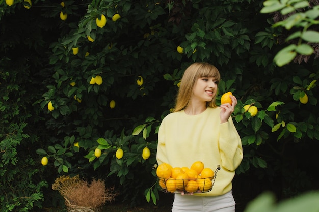 Bella ragazza raccoglie un limone da un albero