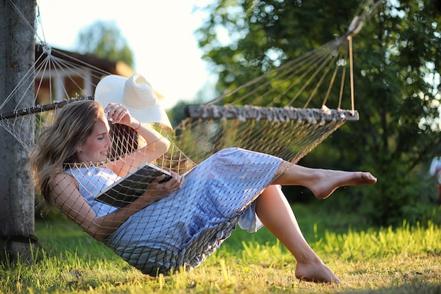 Bella ragazza sdraiata e leggendo un libro in estate all'aperto