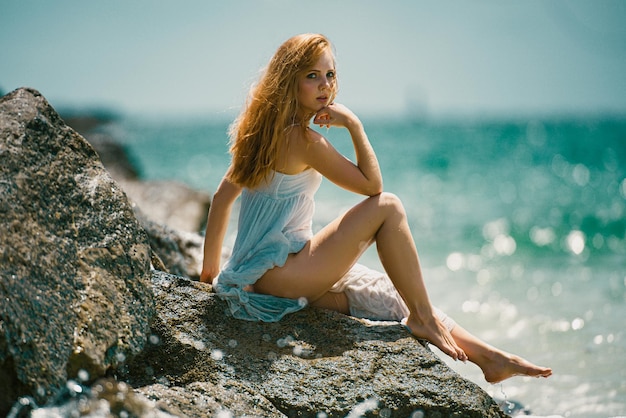 Bella ragazza sexy sul mare roccioso spiaggia moda ritratto di modello all'aperto sulla spiaggia