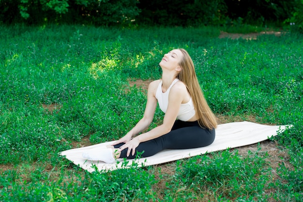 Bella ragazza si allena nella natura e medita