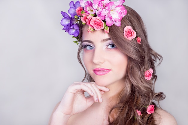 Bella ragazza sorridente con fiori tra i capelli