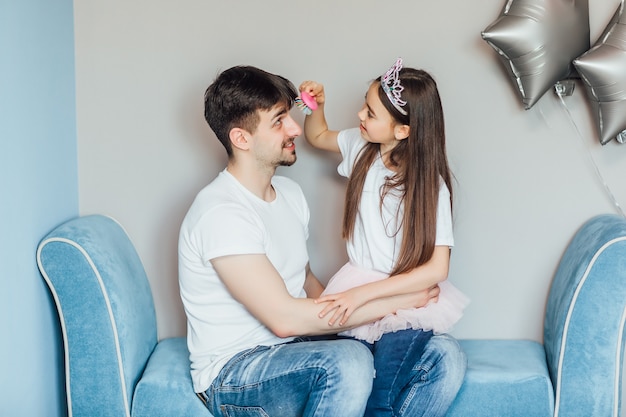 Bella ragazza sta facendo i capelli di suo padre