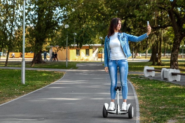 Bella ragazza su un hoverboard bianco nel parco