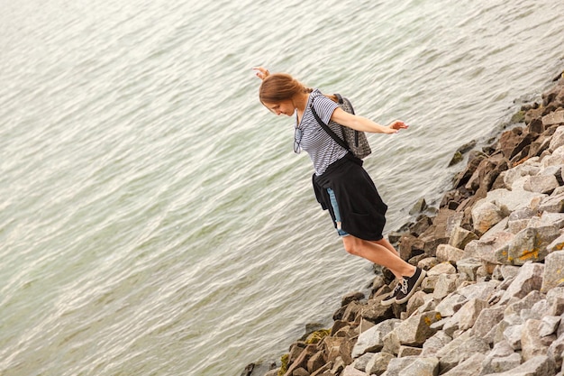 Bella ragazza sul mare con cielo blu e nuvole