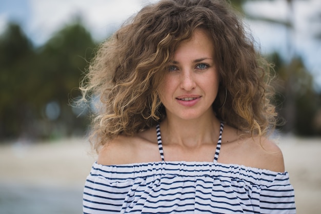 Bella ragazza sulla spiaggia con palme