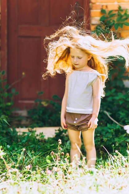 bella ragazza sullo sfondo della porta con i capelli sollevati dal vento