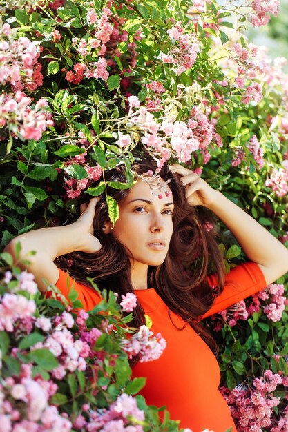 Bella ragazza tra i fiori che sbocciano