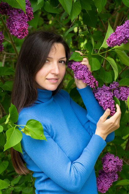 Bella ragazza vicino al lillà