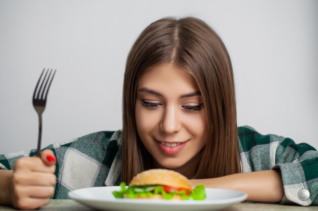 Bella ragazza vuole mangiare hamburger dannoso