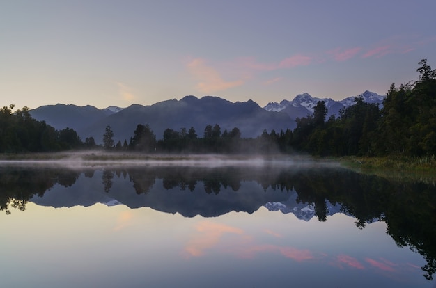 Bella riflessione del lago Matheson nel crepuscolo all'alba con nebbia e Mount Cook / Aoraki e Mount Tasman, Isola del Sud della Nuova Zelanda