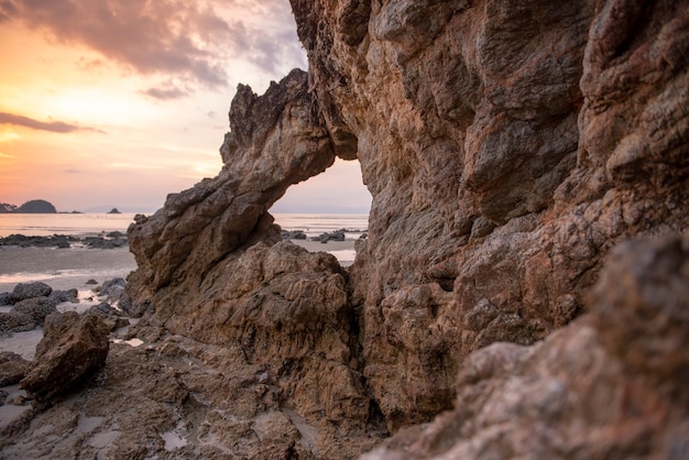 Bella roccia sulla spiaggia al tramonto