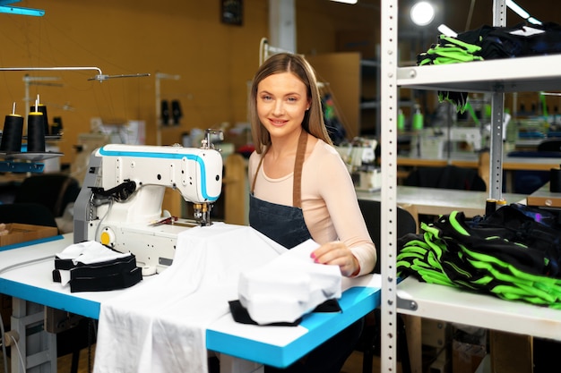 Bella sarta femminile che lavora con il tessuto nel suo luogo di lavoro