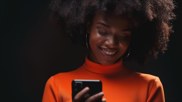 Bella signora africana vestita di arancione che sorride al telefono.