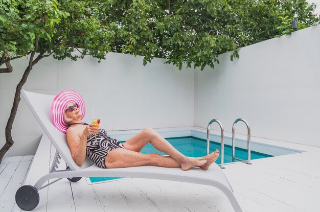 Bella signora anziana che prende il sole e si rilassa in una piscina privata durante l'estate