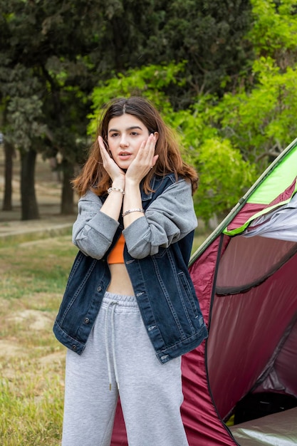 Bella signora in piedi davanti alla tenda e si portò le mani al viso