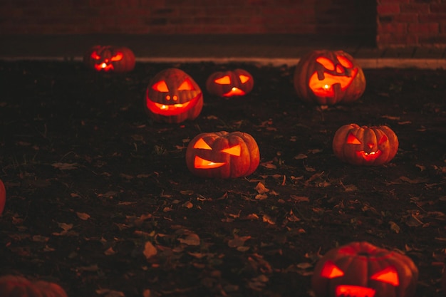 Bella sorridente bagliore arancione divertente faccia zucche intagliate per le vacanze di Halloween di notte all'aperto