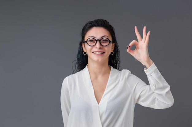 Bella sorridente ritratto di giovane donna turca Indossa un elegante occhiali da vista è felice e pollice in alto Lo spazio di copia include