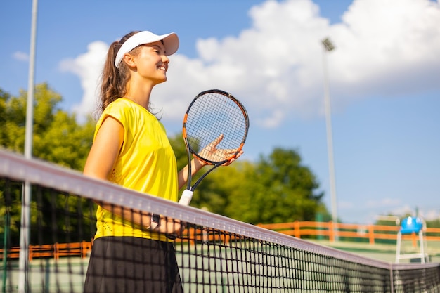 Bella sportiva con la racchetta al campo da tennis Stile di vita sano