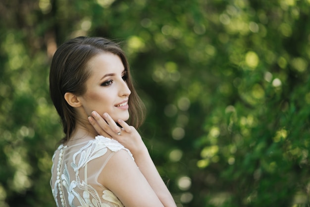 Bella sposa castana con i riccioli in natura