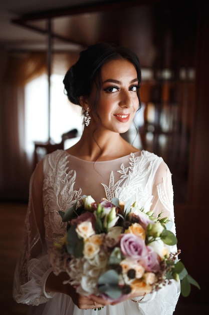 Bella sposa con un bouquet da sposa Bella donna con trucco professionale, stile di capelli Giorno delle nozze